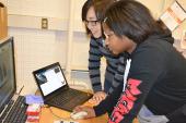 MRL staff member assists middle school student using the scanning electron microscope (Photo by E. Innes, I-STEM)